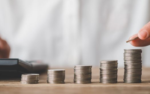 Person stapelt Geldmünzen