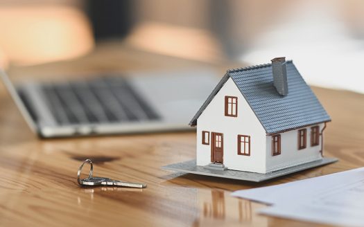 Hausmodell neben Laptop